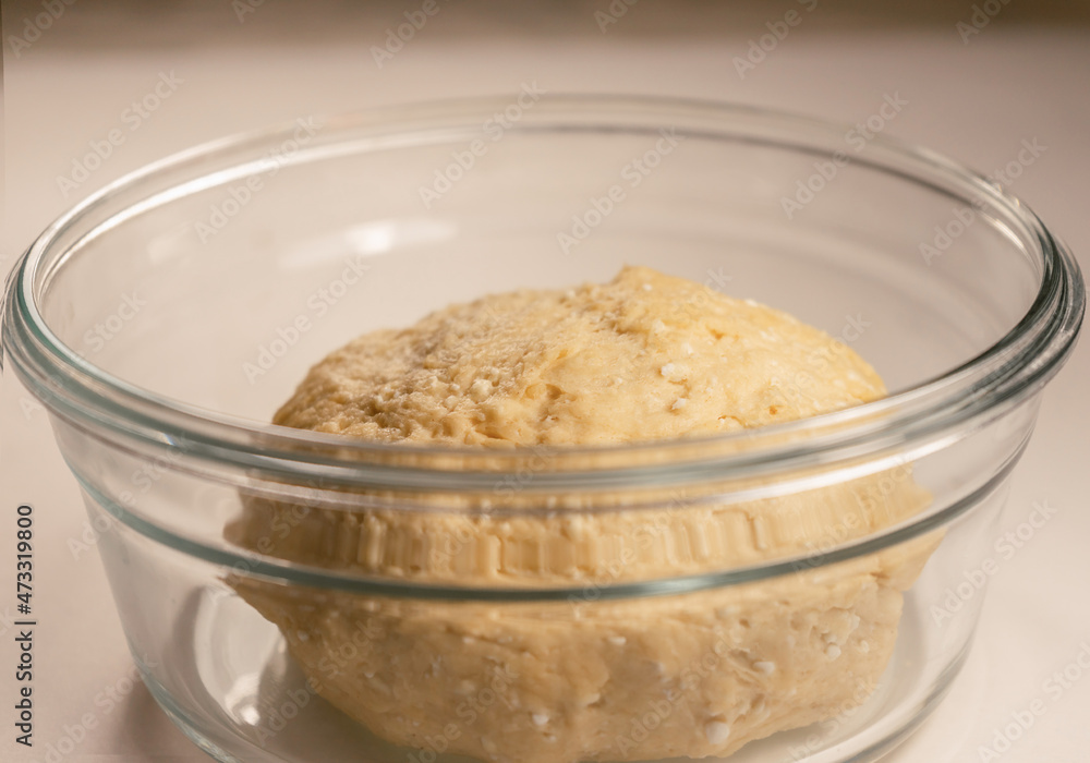 Cottage cheese dough in a glass dish on the table