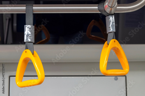 Close-up of an empty yellow handrail or handles for passenger in metro. Concept about social distance