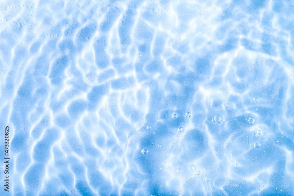 Blurred blue clear calm water surface texture with splashes and bubbles. abstract nature background. Water waves.