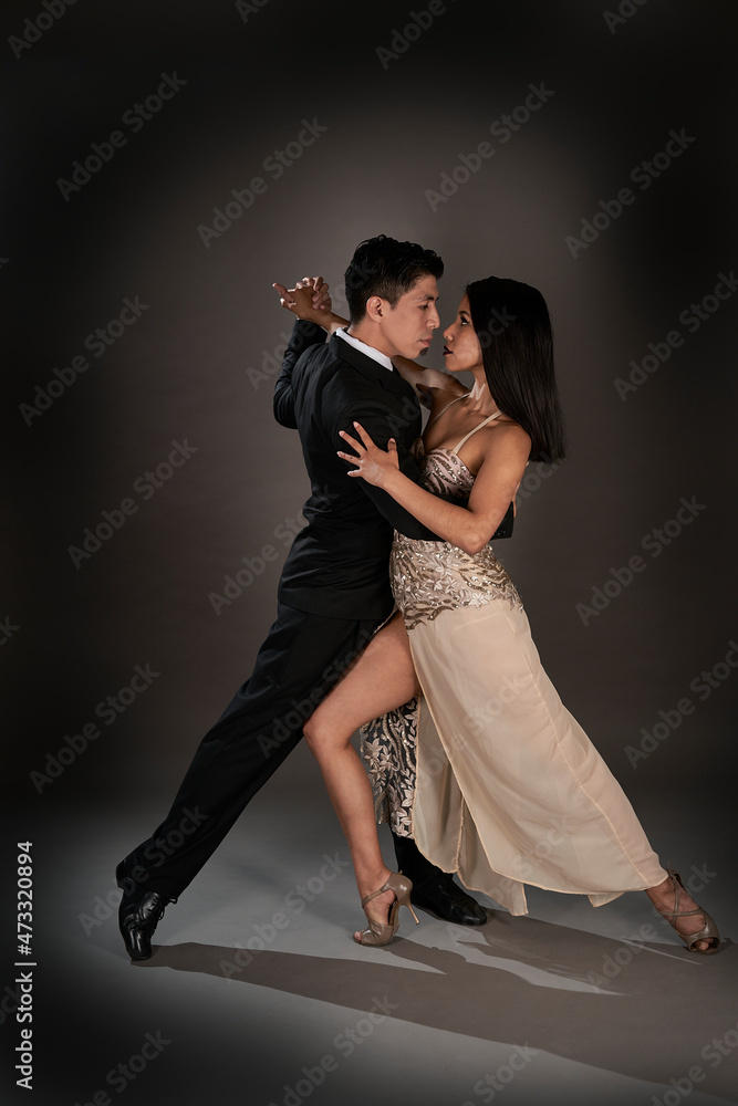 Latin woman and asian man dancing tango ballroom. studio shot Latin woman and asian man dancing tango ballroom. studio shot