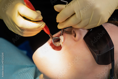 real. dentist examines patient s teeth. regular care and prevention.