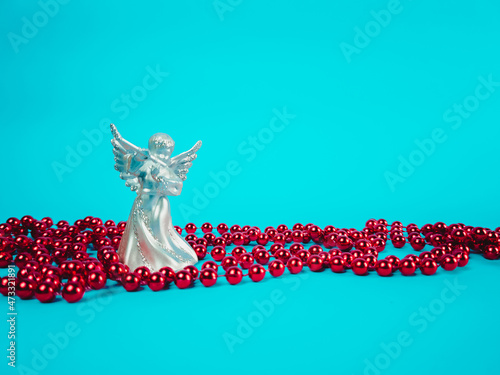 Christmas angel statue with decorations on a blue background (ID: 473321891)