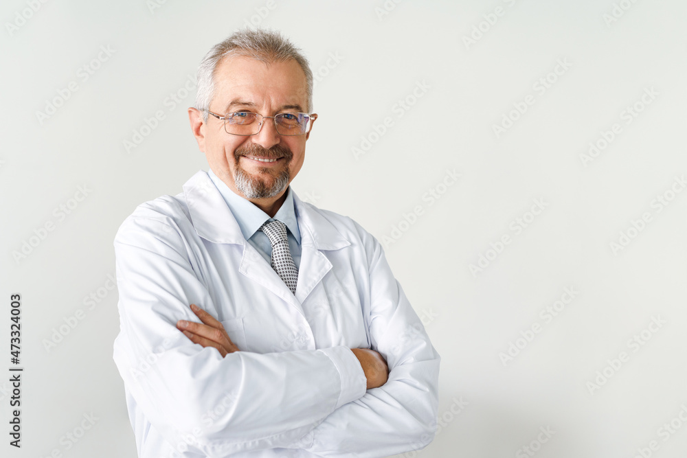 Portrait of an elderly male doctor on a white background. Friendly doctor smiling while looking at the camera. Portrait of an elderly male doctor on a white background. Friendly doctor smiling while looking at the camera.