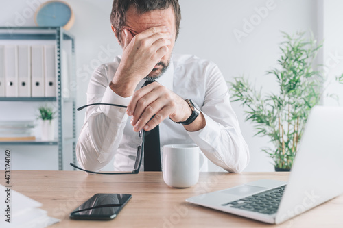 Businessman and entrepreneur realizing the big mistake he made, hand covering face in disbelief photo