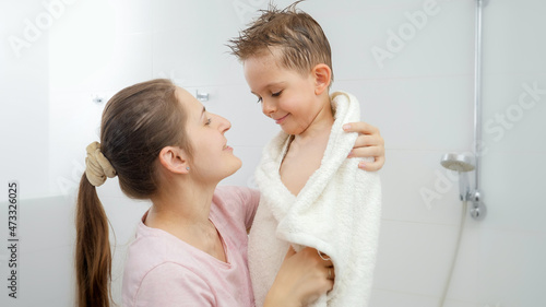 Caring mother drying her son with towel and hugging after bathing. Concept of hygine  children development and fun at home