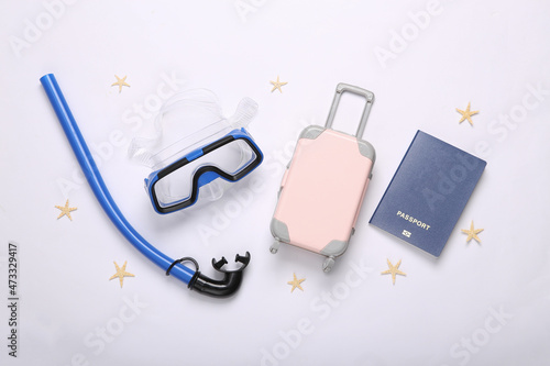 Passport, luggage, snorkel and diving mask on white background. Travel concept, vacation at sea. Flat lay, top view