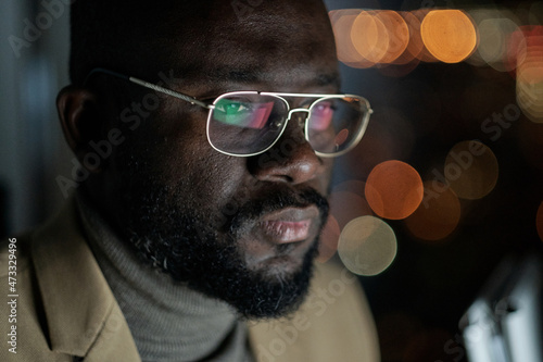 Fényképezés Young African businessman in eyeglasses concentrating on network while working l