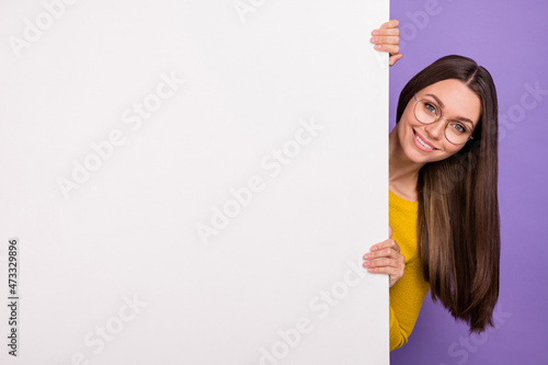 Photo of young cheerful girl hold hands paper advert announcement isolated over purple color background