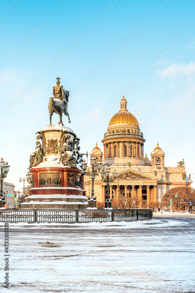 View of the monument to Nicholas I and St. Isaac's Cathedral on a snowy winter day in St. Petersburg. Postcard tourist view