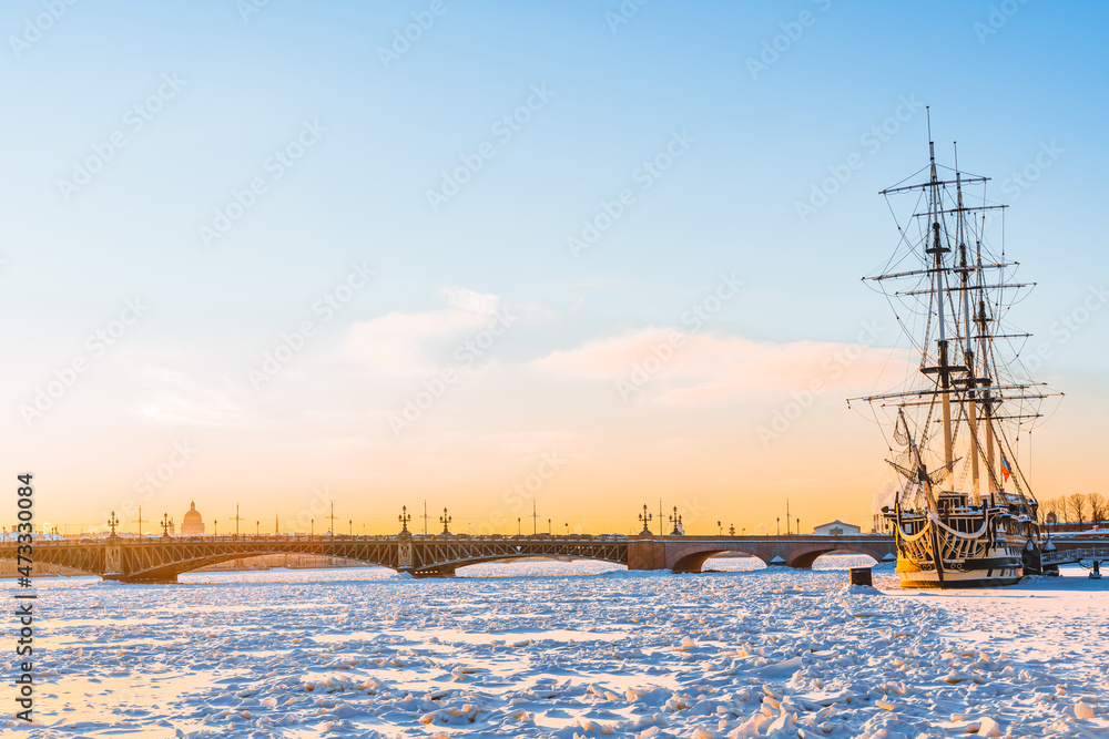 Frigate ship on the embankment of St. Petersburg on the frozen Neva River in winter in the snow. Beautiful tourist postcard.