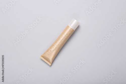 Tube of foundation on gray background. Top view
