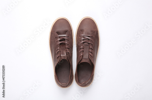 Mens brown leather sneakers on a gray background