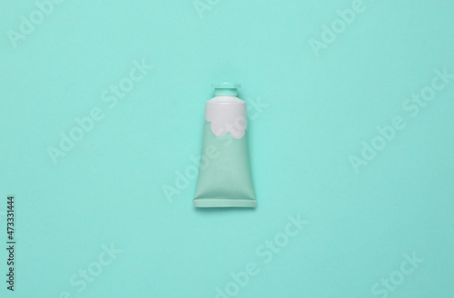 Tube of cream on a turquoise background. Top view. Minimalism