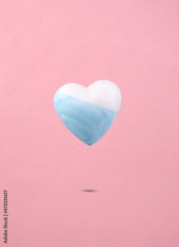 Levitating heart with dripping paint paint on a pink background. Minimal creative layout. Concept art.