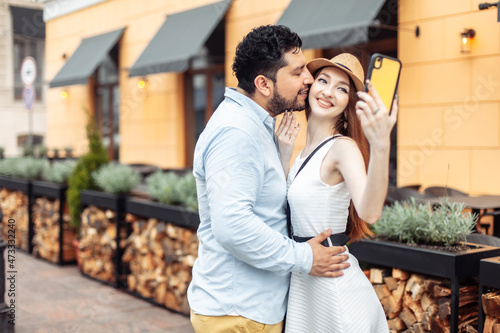 Cute international couple of tourists in love taking selfie on smartphone in the city © splitov27