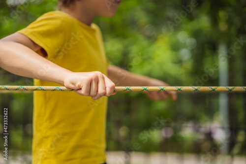 Little boy in a rope park. Active physical recreation of the child in the fresh air in the park. Training for children