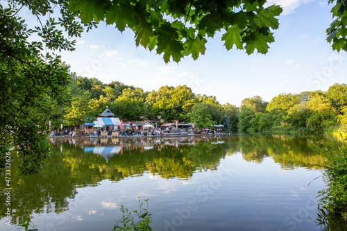 Germany, Bavaria, Munich, Mollsee lake in Westpark with beer garden in background
