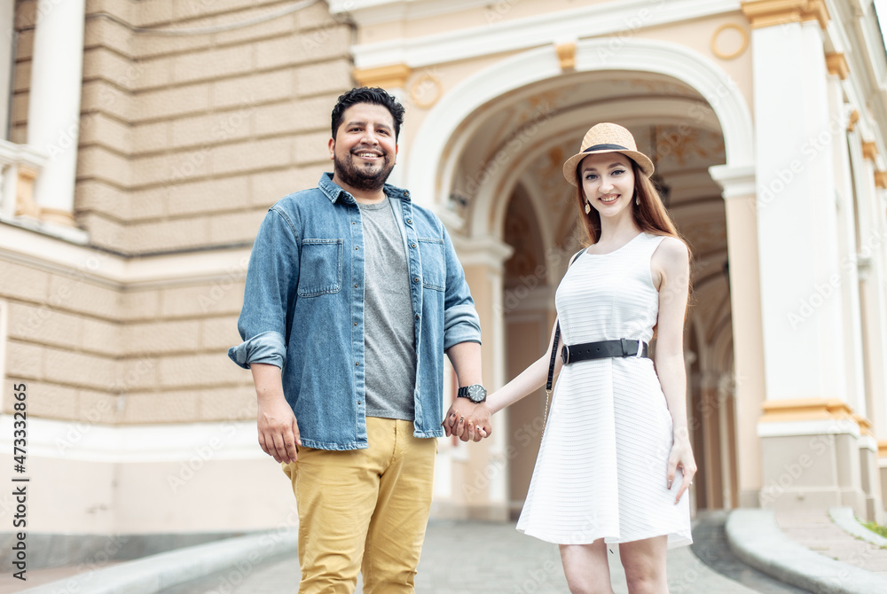 Young international couple in love walking in european city