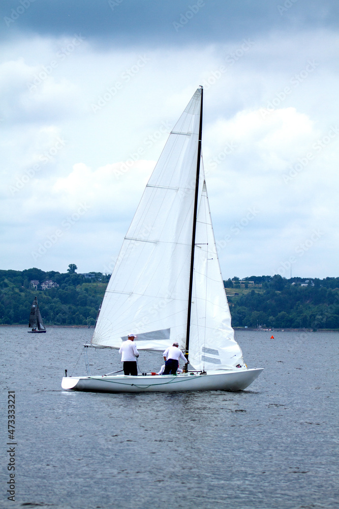 Obraz premium Yacht with white sails on the water, sea and river transport, blue sky, beautiful background.