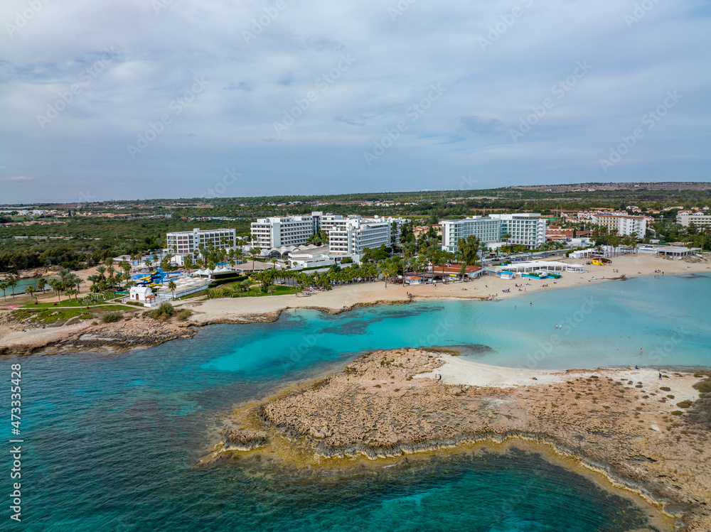 Fototapeta premium Nissi Beach in Ayia Napa, clean aerial photo of famous tourist beach in Cyprus, the place is a known destination on island and is formed from a smaller island just near the main shore