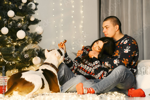 Cute couple sitting at home near christmas tree