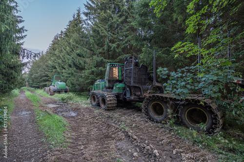 Forwarder parked along muddy forest road photo