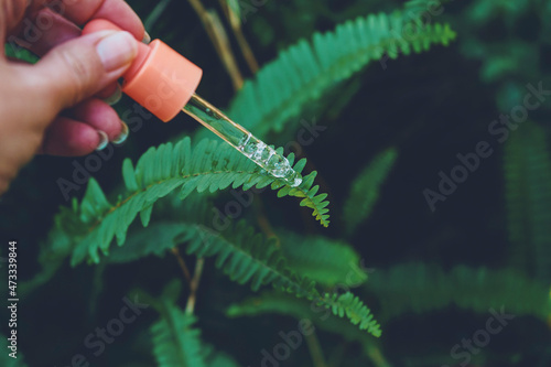 Woman putting serum on plant