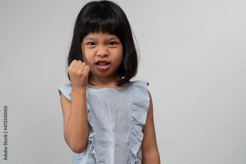Portrait of Asian angry and sad little girl on white isolated background, The emotion of a child when tantrum and mad, expression grumpy emotion. Kid emotional control concept Portrait of Asian angry and sad little girl on white isolated background, The emotion of a child when tantrum and mad, expression grumpy emotion. Kid emotional control concept