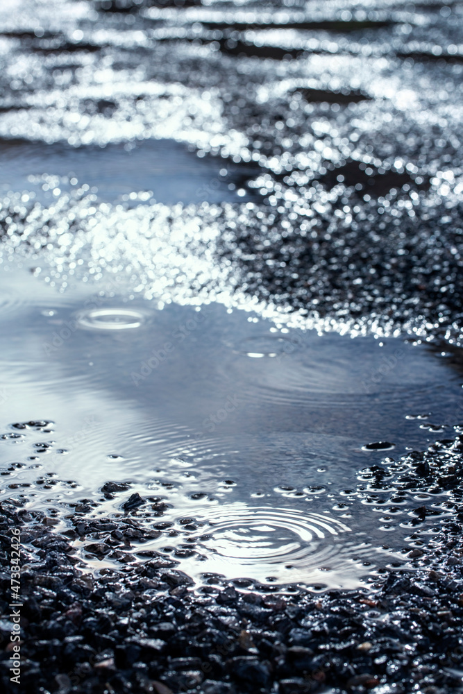 water puddles with water on cracked wet asphalt road after hard rain fall,rainy season background. water puddles with water on cracked wet asphalt road after hard rain fall,rainy season background.