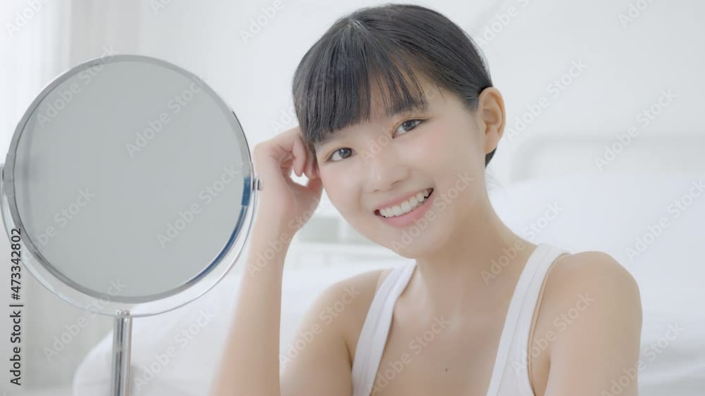 Beautiful face of young asian woman with happy smiling and touch cheek looking mirror with charming, makeup of beauty facial girl with skincare and cosmetic treatment, skin care and healthy concept. Beautiful face of young asian woman with happy smiling and touch cheek looking mirror with charming, makeup of beauty facial girl with skincare and cosmetic treatment, skin care and healthy concept.