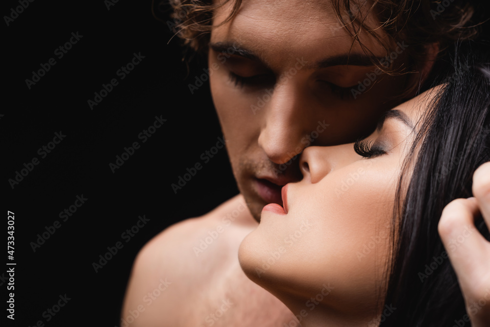 close up of young passionate couple with closed eyes isolated on black. close up of young passionate couple with closed eyes isolated on black.