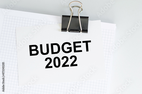 White card with the text BUDGET 2022 on clip to notebook on table, business concept
