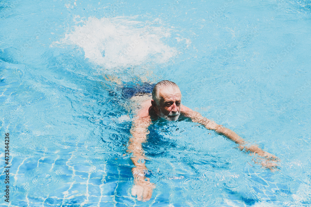 caucasian elder, senior mature man resting in swimming pool