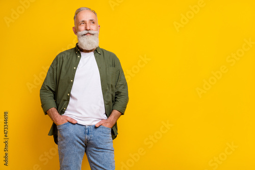 Photo portrait of senior man smiling confident wearing casual clothes looking copyspace isolated vivid yellow color background