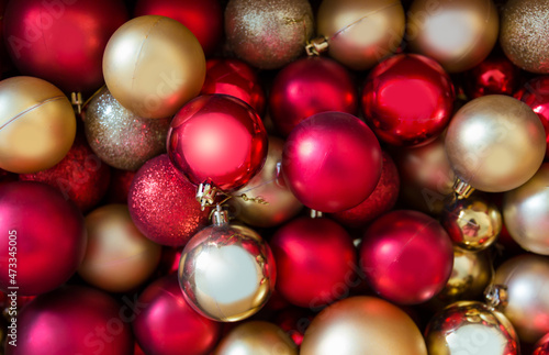 Full frame shot of Christmas ornaments, red and gold Christmas tree decorations.
