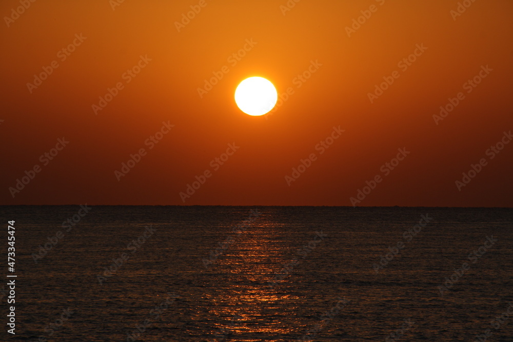 sun disc over blue sea