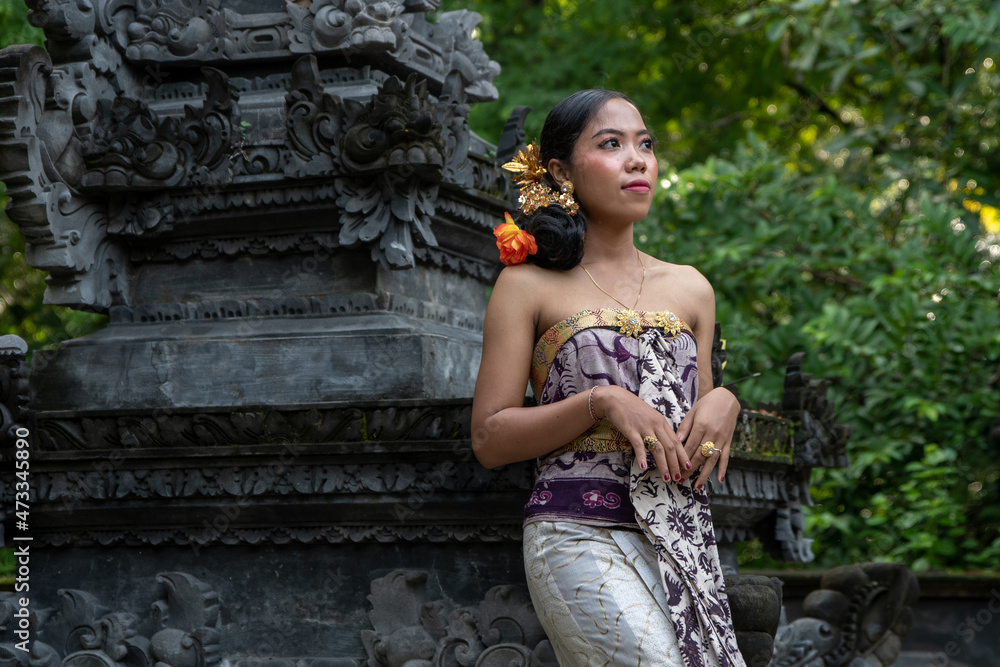 Balinese girl in a Hindu temple in Bali with incense sticks dressed in traditional dress. Balinese girl in a Hindu temple in Bali with incense sticks dressed in traditional dress.