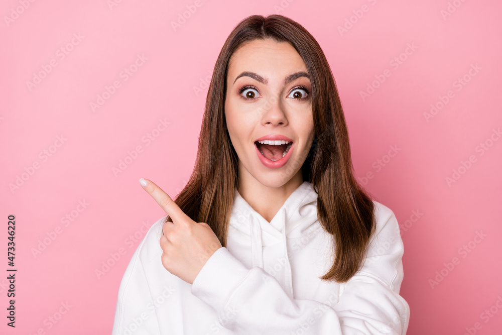 Photo of young girl happy positive smile indicate finger empty space select suggest discount isolated over pink color background Photo of young girl happy positive smile indicate finger empty space select suggest discount isolated over pink color background