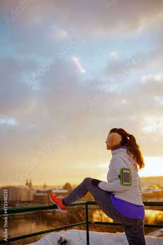 young woman in white jacket stretching