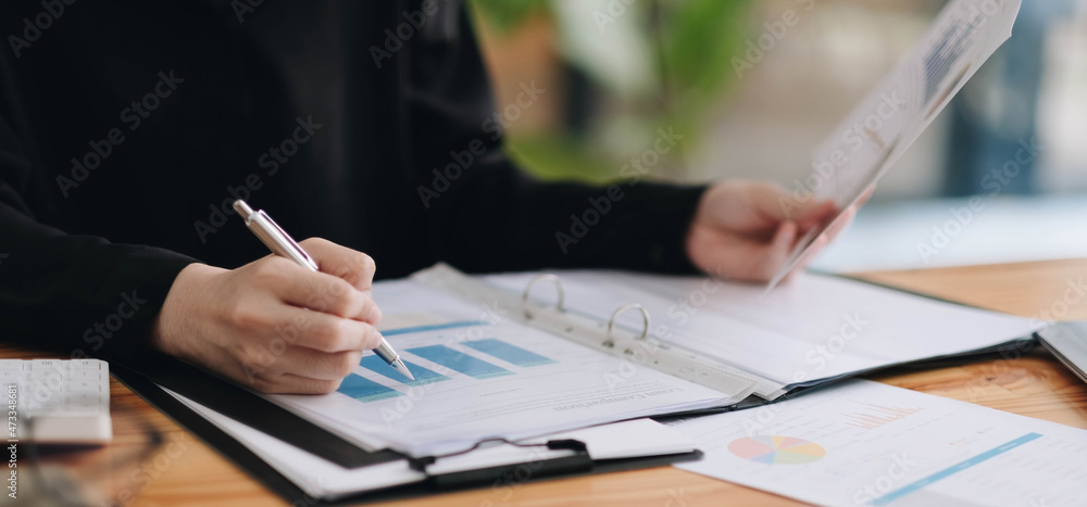 Businesswomen are analyz data from report and laptop computer with finance stock market. finance concept.