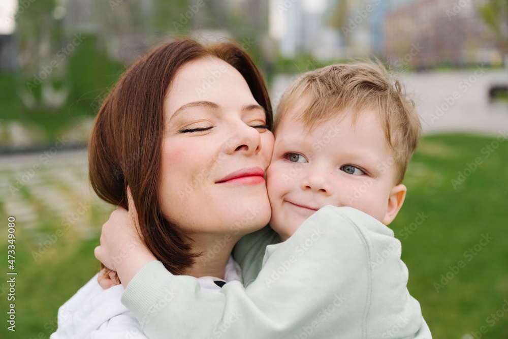 Cute son embracing mother at public park Cute son embracing mother at public park
