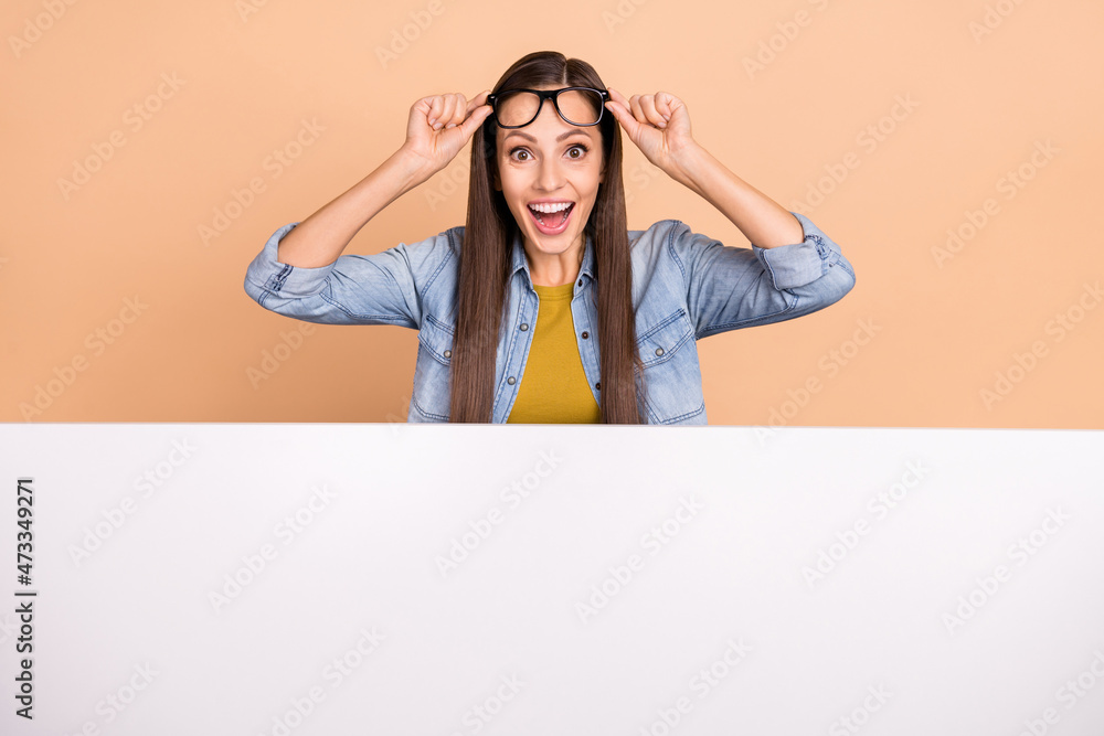 Photo of happy amazed female see huge sale discount on black friday billboard placard isolated on beige color background