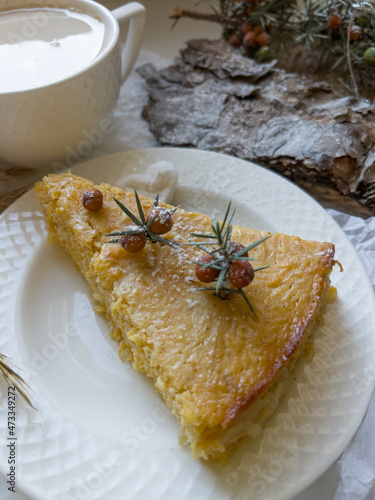 Still life with slice of apple pie, cup of latte coffee and pine bark sprinkled with powdered sugar