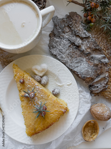 Cup of latte coffee and piece of apple pie on a decorated holiday table
