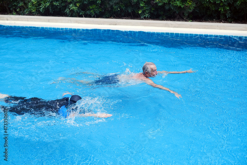 asia senior woman training caucasian old man swimming together