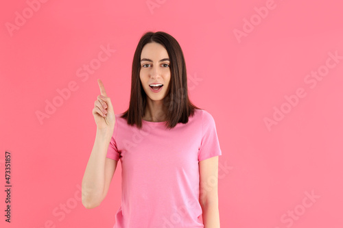 Young attractive woman in t-shirt on pink background © Atlas
