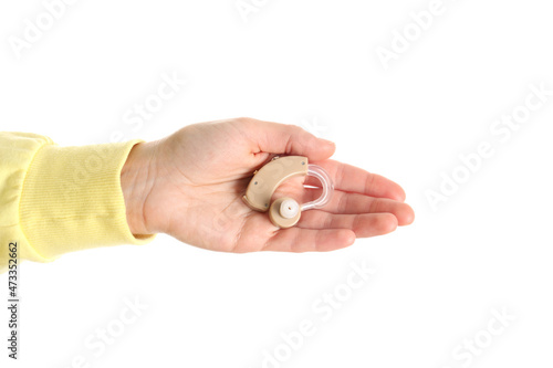 Female hand holds hearing aid, isolated on white background