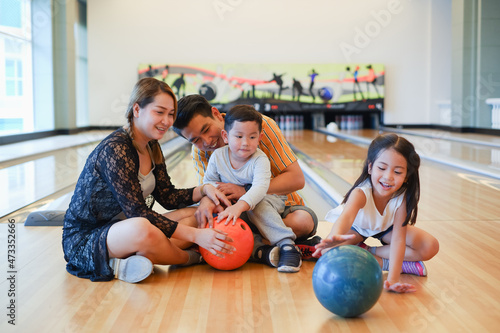 asia family playing bowling together