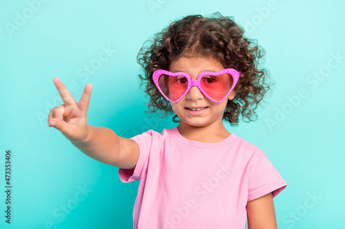 Portrait of attractive cheerful girl wearing big specs showing v-sign isolated over bright teal turquoise color background
