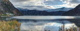 Panorama photo of Lake Lugano in winter with snowy mountains. 